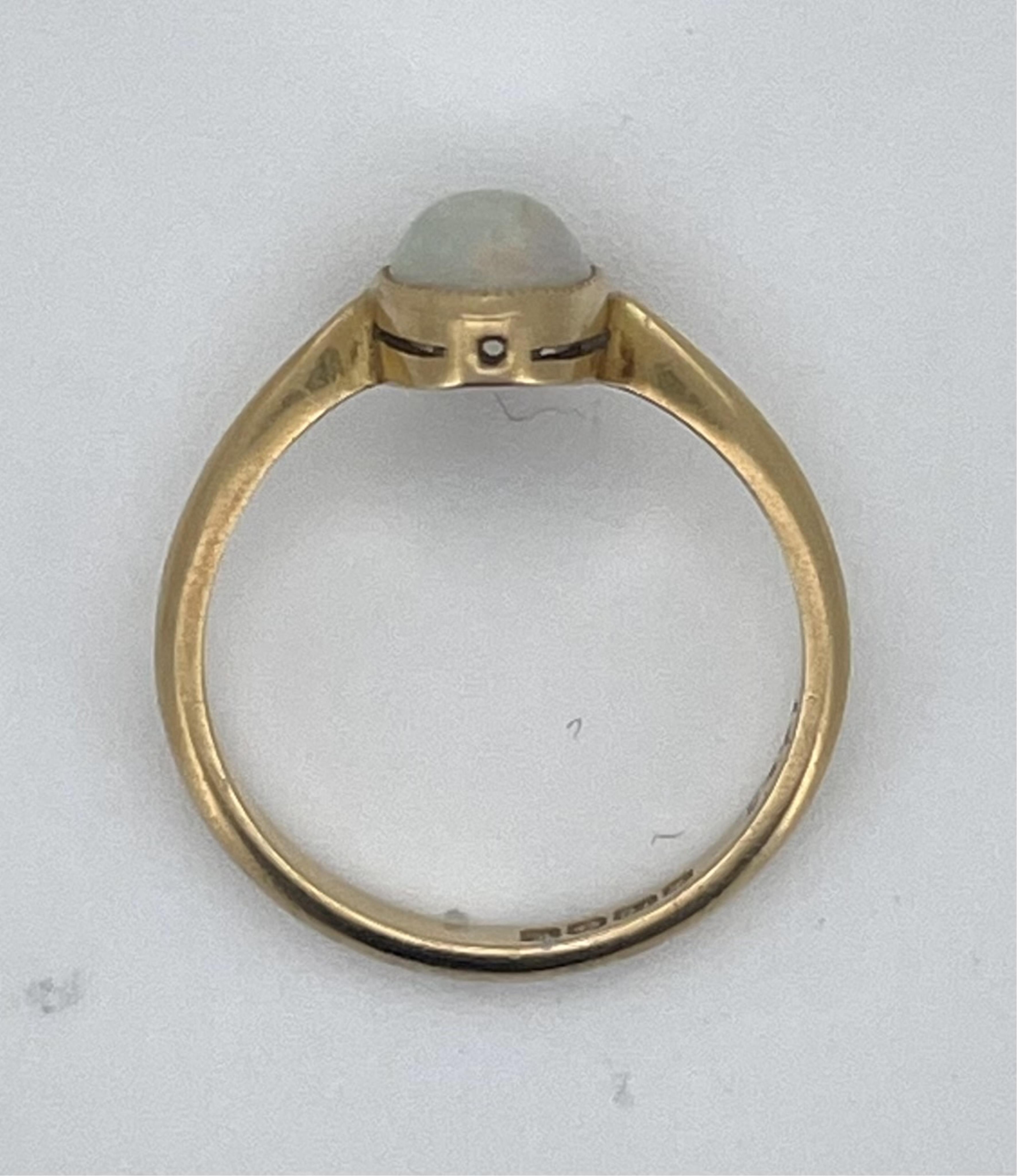 A 1970's 18ct gold and single stone oval white opal set ring, size L, gross weight 2.5 grams.